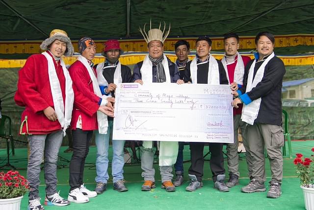Chief Minister Pema Khandu handing over a compensation cheque to residents of Mago who gave up their land for construction of the road.
