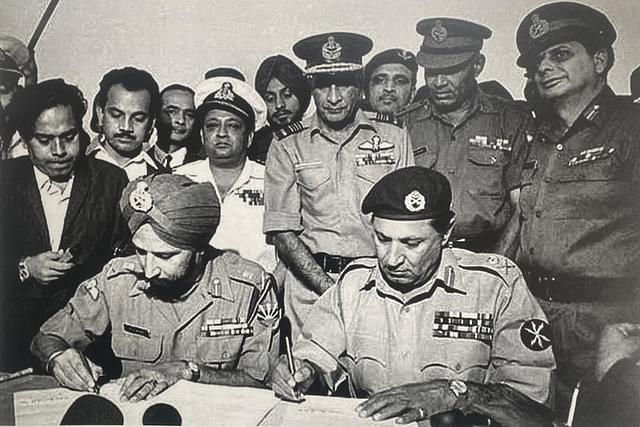 Lt. General A A K Niazi signing surrender document with Lt. General Jagjit Singh Aurora GOC-in-C of all Indian forces in the eastern theatre. (Image via X @IAF_MCC) 