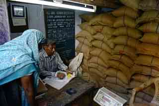 Vendor processes the ration card of an Indian woman at his Fair Price Shop.  (Representative Image) 