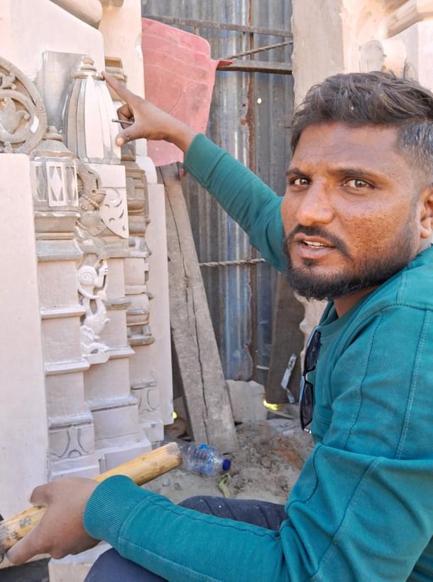 Virendra explaining the meaning of the carvings, while pointing at the Shikhara that has been recreated on the stone. (Source: Swarajya)