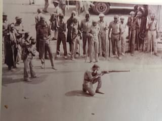 Picture of a policeman firing at civilians in 1990.