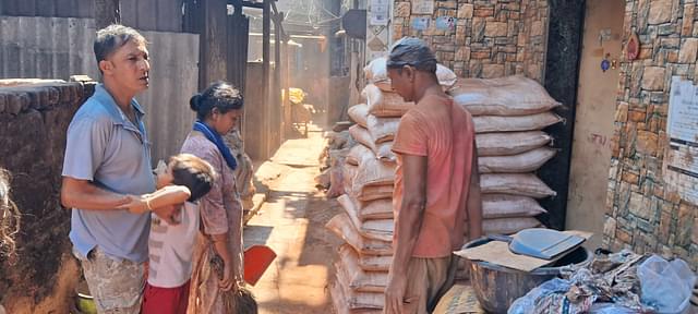 Dinesh, his family outside their hut receiving sand for week's work. (Ankit Saxena/Swarajya)
