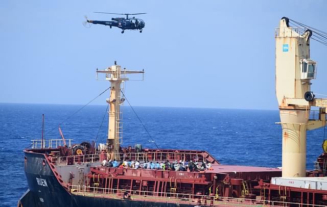 Somali pirates surrendering while an Indian Navy's Chetak helicopter can be seen hovering over the ship, MV Ruen. (X/@indiannavy)
