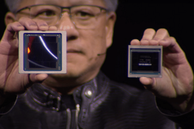 NVIDIA chief holding up the new Blackwell GPU alongside its predecessor, Hopper.