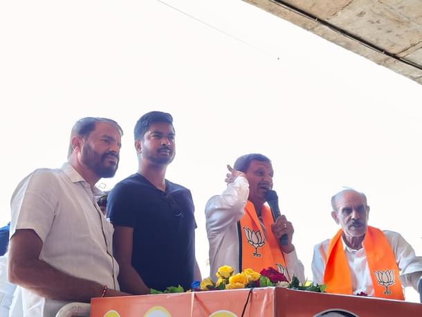 Sharan Setty standing next to Dr Manjunath on the campaign vehicle.