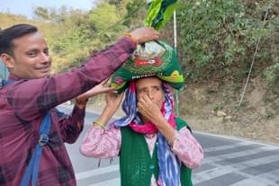 A beneficiary of Centre's free ration and Ayushman Bharat schemes in Pauri Garhwal asks a youth for help (Image credit: Sumati Mehrishi)