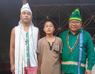 Jatindra Reang with his sons. His elder son is a Sampurna Jawan and is clad in the white ritual dress. Jatindra is a Dasi, but his status as a chief spokesperson allows him to wear a special green attire.