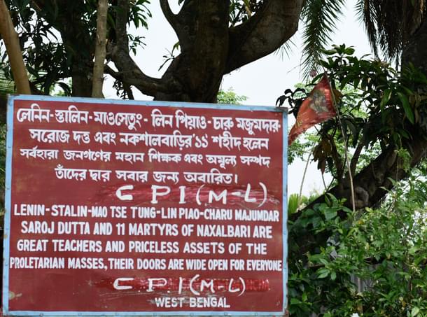 A saffron flag with Hanuman's image flies defiantly in the backdrop of a board put up by CPI(ML) (Image credit: Sayan Sarkar)