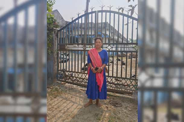Papiya Burman Roy in front of the community hall that was constructed on the land allegedly taken from her family by force.