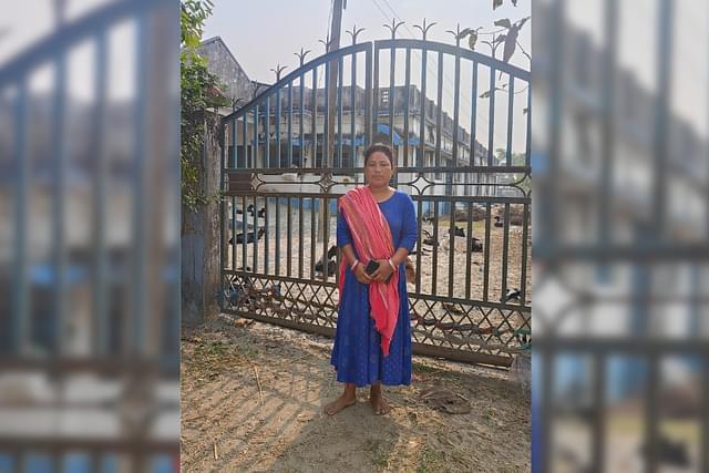 Papiya Burman Roy in front of the community hall that was constructed on the land allegedly taken from her family by force.
