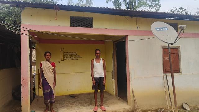 Rajesh Orang with his wife in front of their PMGAY house.