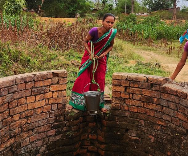 Sebati Rana lifts water from the well in the outskirts of Babupara
