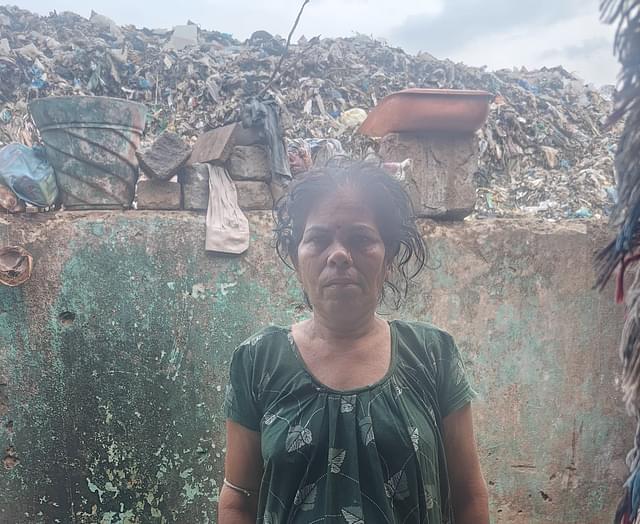 Gauri Malik in her house at Bisheshwar Basti. The landfill can be seen behind her.
