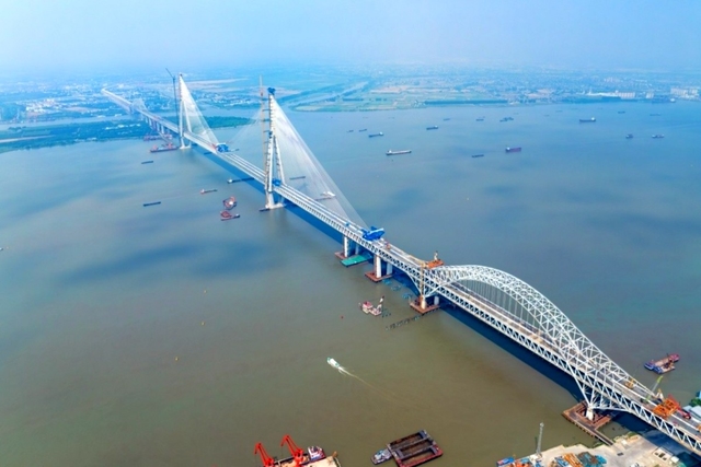This construction holds multiple world records, setting benchmarks for the largest span dual-use road and rail steel truss arch bridge, and the longest continuous steel truss structure.(CMG)