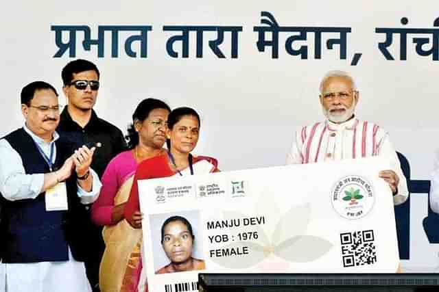 PM Modi distributes Ayushman Bharat cards at an event.