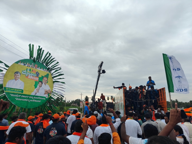 JD(S) workers with flags and posters supporting Nikhil Kumaraswamy.