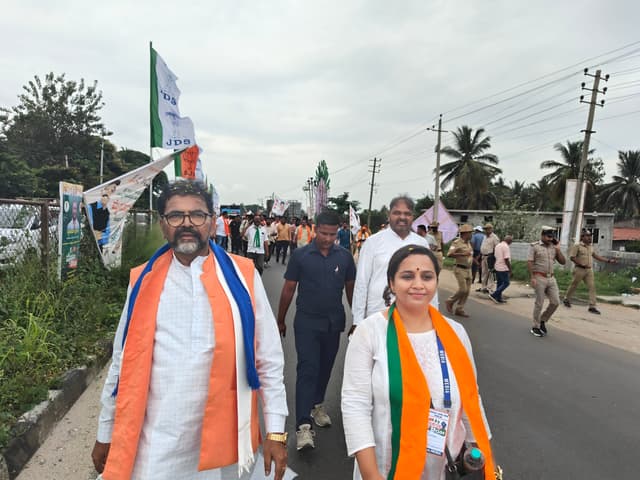 BJP's Surabhi Hodigere walks with Chalavadi Narayanaswamy during the march.