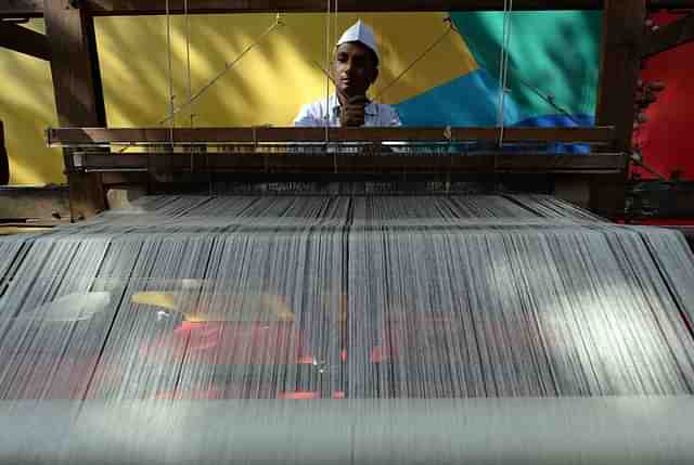 An artisan weaves traditional khadi cloth on a handloom (Photo credit: RAKASH SINGH/AFP/Getty Images)