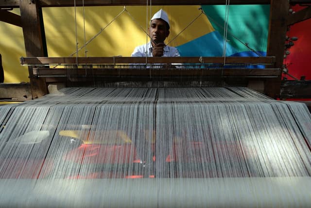 An artisan weaves traditional khadi cloth on a handloom (Photo credit: RAKASH SINGH/AFP/Getty Images)