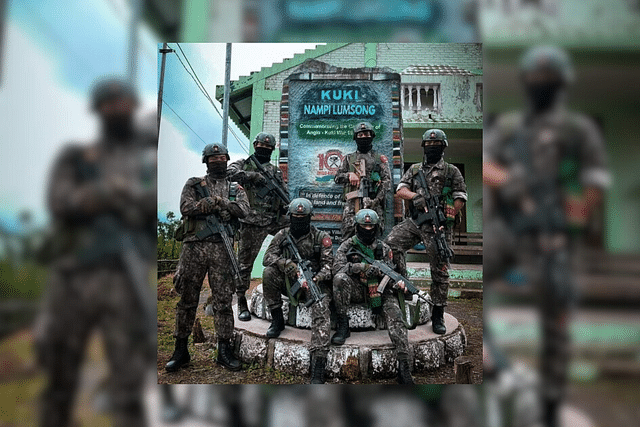 Cadres of a Kuki terror outfit pose with their weapons in front of a community memorial at Changoubung village in Manipur's Senapati district