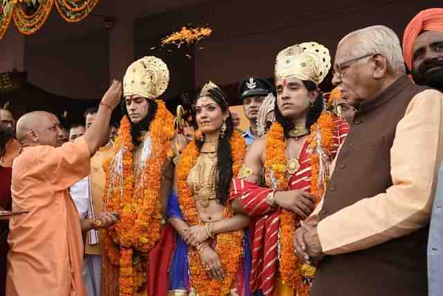 Uttar Pradesh CM Yogi Adityanath showers petals on artistes dressed up as Lord Rama, Sita and Lakshman in Ayodhya. (Deepak Gupta/Hindustan Times)