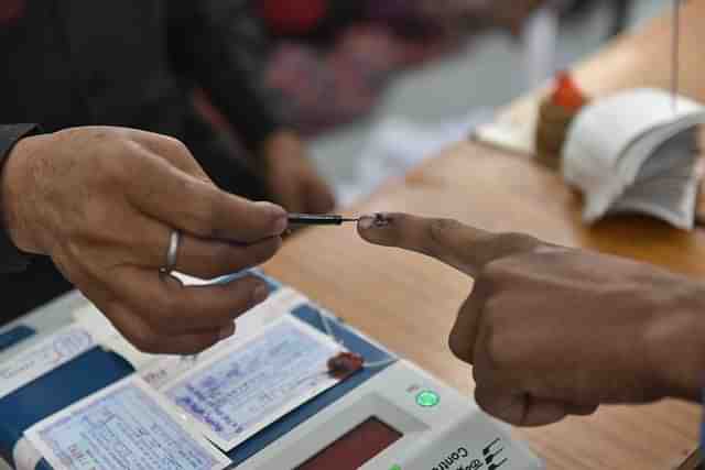 An election officer applies an indelible ink mark on the finger during voting (Mujeeb Faruqui/Hindustan Times via GettyImages) 