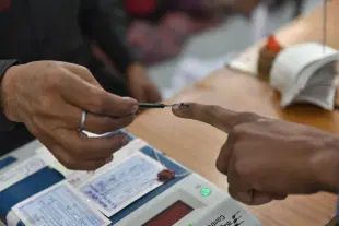 An election officer applies an indelible ink mark on the finger during voting (Mujeeb Faruqui/Hindustan Times via GettyImages)