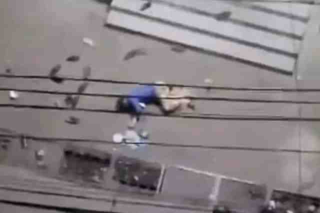 A Hindu man, probably dead, lies on a street in Chittagong city and army soldiers look on 