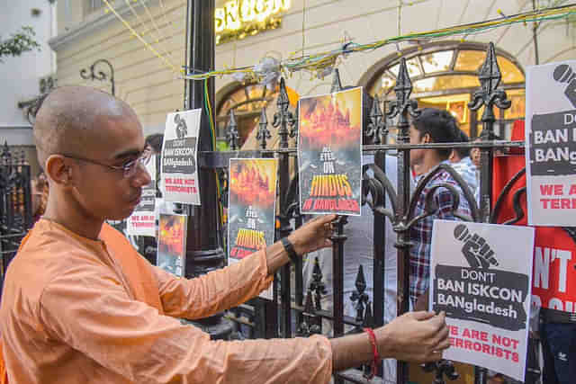 An ISKCON monk puts up posters outside the ISKCON temple in Kolkata