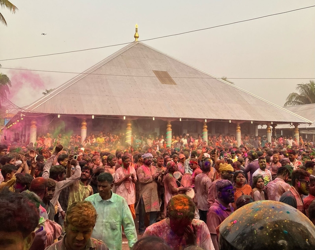 People play with phakuguri (gulal) in the courtyard of the Barpeta Satra