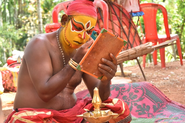 The medium applying make-up before the Daiva Nēmā (Source: Bharathesha Alasandemajalu, Wikimedia Commons)
