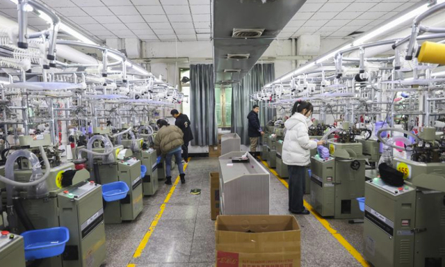 Workers are busy with orders for export in a workshop of a sock company at the Datang in east China's Zhejiang Province (Src: Global times)