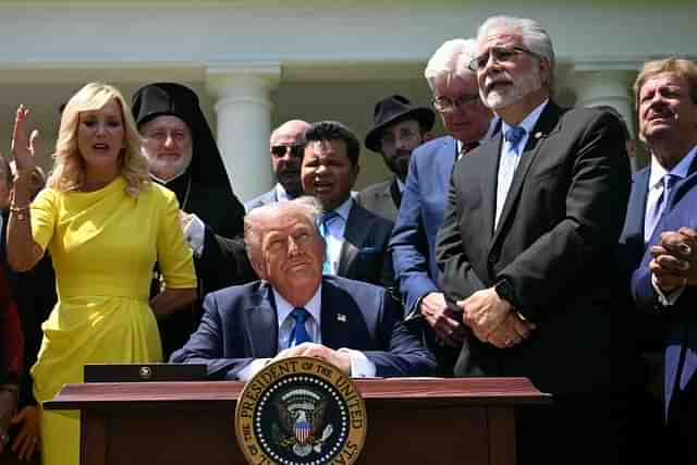 President Donald Trump signs executive order on the "Establishment of the Religious Liberty Commission", surrounded by faith leaders, on the National Day of Prayer. (Jim Watson / AFP via Getty Images)