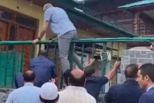 Omar Abdullah hauling himself over a boundary wall.