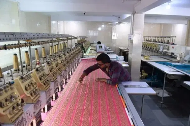 An Indian textile maker works on an embroidery machine at a workshop. (SAM PANTHAKY/AFP/GettyImages)