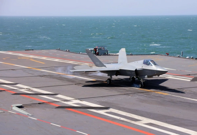A Chinese fighter completes takeoff and landing drills on the flight deck of China’s new Fujian aircraft carrier.

