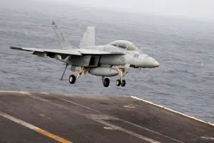 An F/A-18F Super Hornet of the US Navy lands on an aircraft carrier.