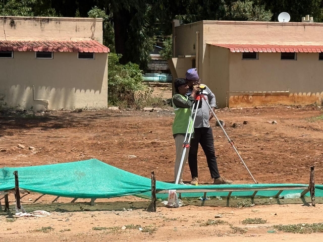 Workers survey a site (TR Ramesh).